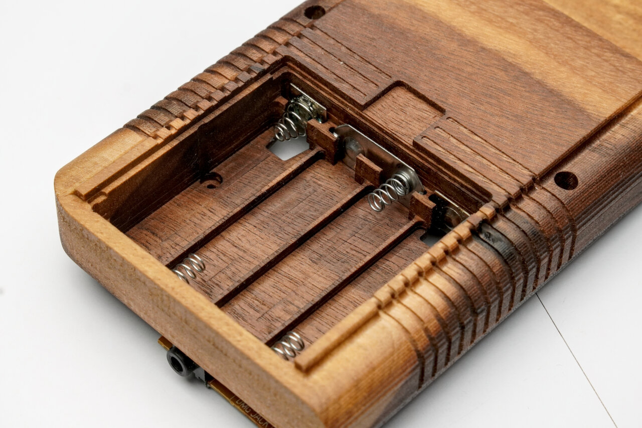 Photo of the battery compartment of the wooden Game Boy shell with contacts in place.
