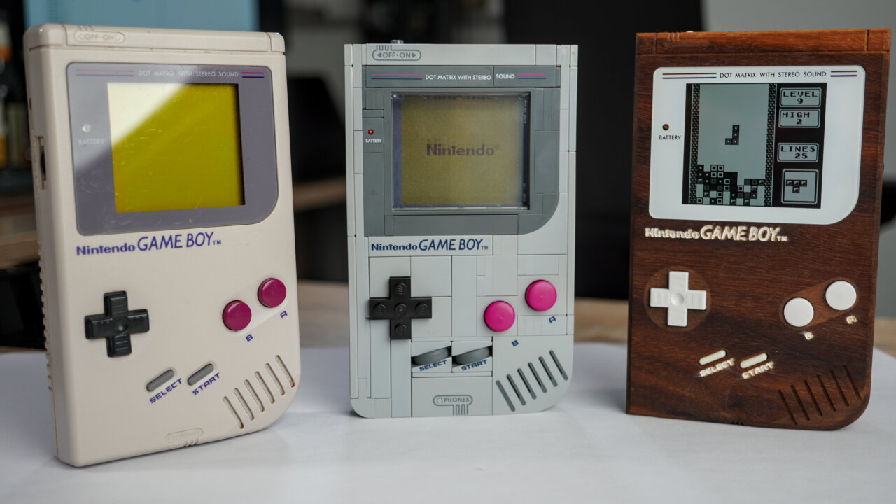 Photo of three Game Boys next to each other. From left to right: The original Game Boy, the Lego Game Boy and the wooden Game Boy.